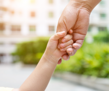 adult holding child's hand