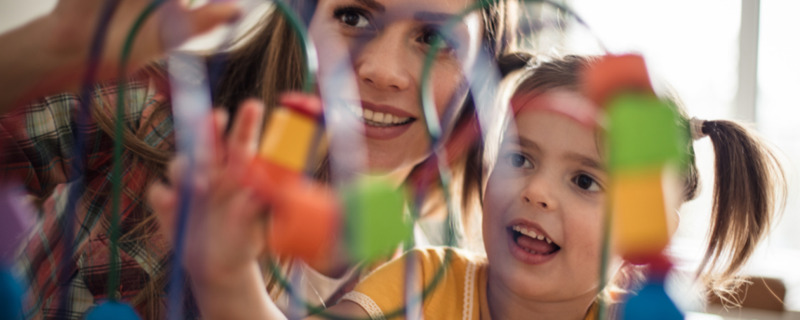 Preschool teacher playing with child